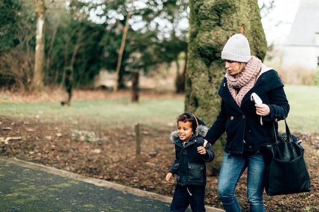 Moeder en kind wandelen samen in een park op een koude winterdag stock foto