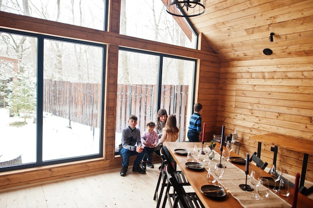 Moeder en kinderen in modern houten huis met tafel tijd samen doorbrengen in warm en liefde