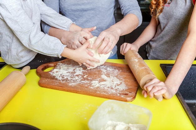 Moeder en kinderen koken in de keuken en plezier maken