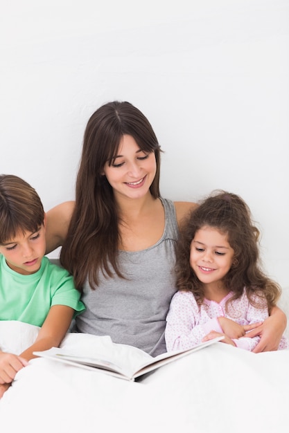 Moeder en kinderen lezen samen boek