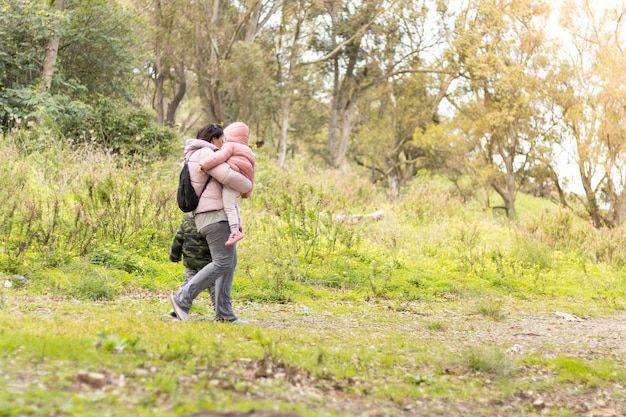 Moeder en kinderen lopen onherkenbaar over het veld