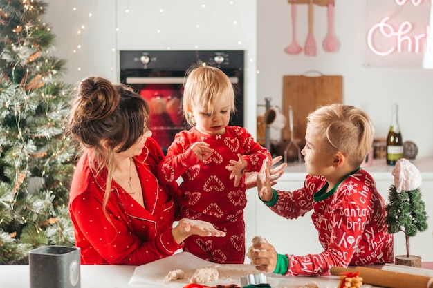 Moeder en kinderen maken kerstkoekjes, vuil worden met meel