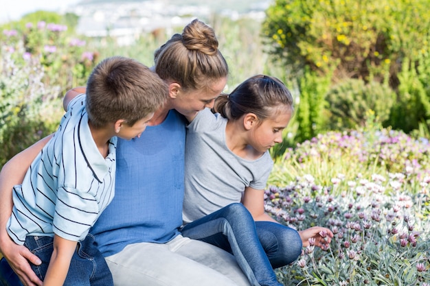 Moeder en kinderen neigen naar bloemen