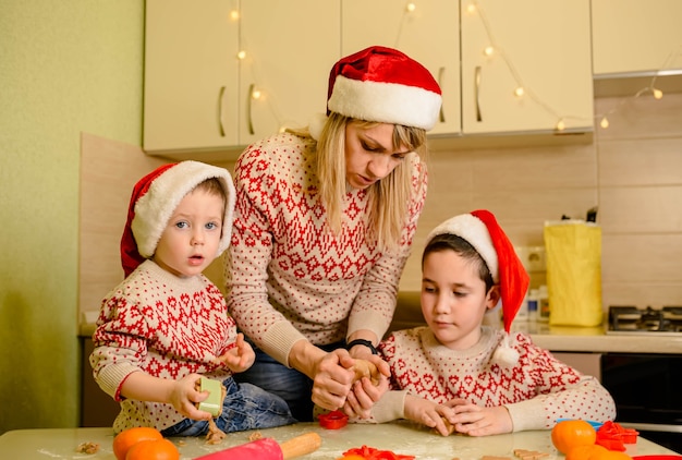 Moeder en kinderen peperkoekkoekjes maken voor Kerstmis