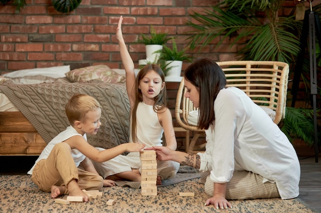 Moeder en kinderen spelen Squirl Tower. Vrouw meisje en jongen spelen familie puzzelspel