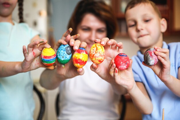 Moeder en kinderen tonen beschilderde eieren voor Pasen