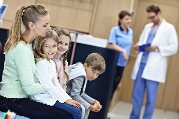 Moeder en kinderen wachten voor de registratiebalie in het ziekenhuis