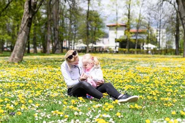 Moeder en klein babymeisje zittend op gras