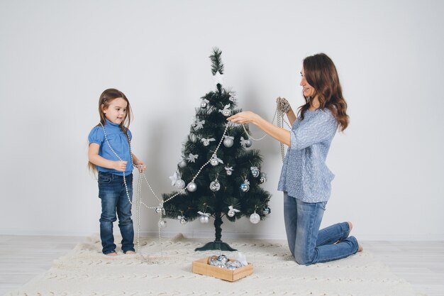 Moeder en kleine dochter versieren kerstboom