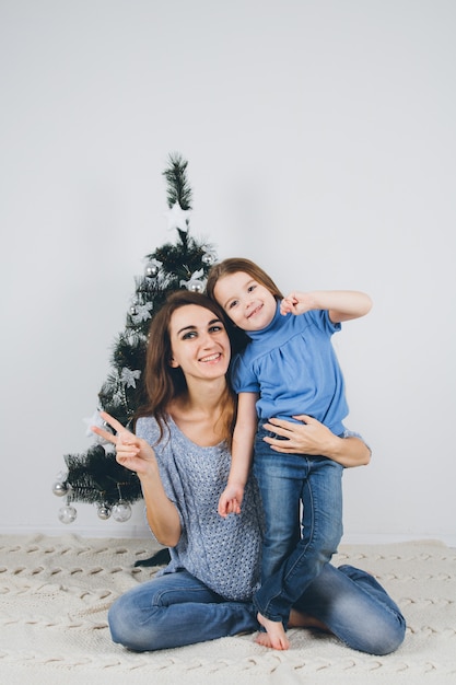 Moeder en kleine dochter versieren kerstboom