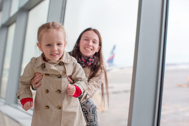 Moeder en meisje in luchthaven wachten op instappen