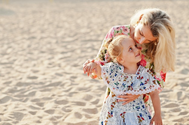 Moeder en mooie dochter die plezier hebben op het strand Portret van een gelukkige vrouw met een schattig klein meisje op vakantie