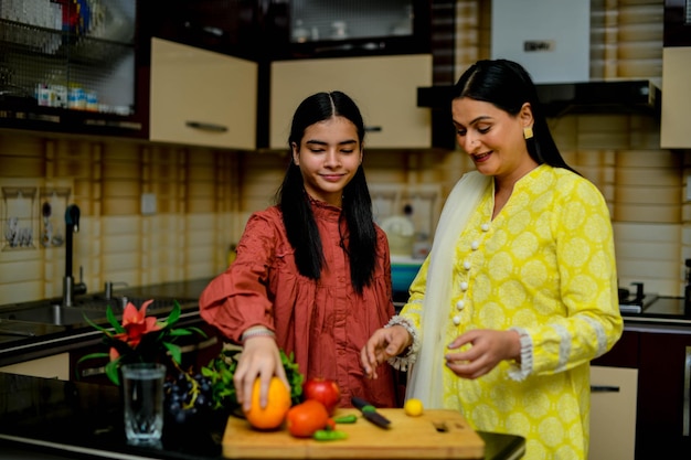 moeder en schattige dochter met fruit in de keuken Indisch Pakistaans model