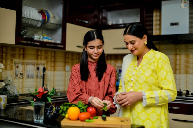 moeder en schattige dochter zijn in de keuken Indiaas Pakistaans model