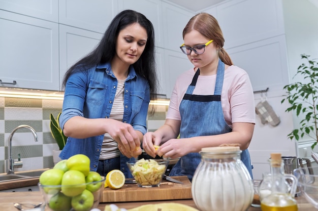 Moeder en tienerdochter bereiden samen appeltaart