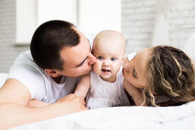 Moeder en vader met kleine baby in een bed