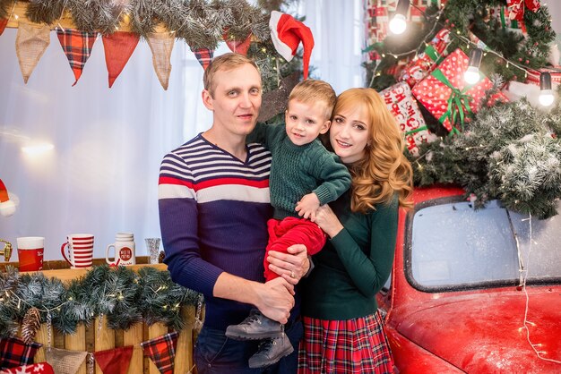 Moeder en vader omhelzen de jongen. Nieuwjaar en Kerstmis. Een gelukkig gezin heeft plezier met hun zoon