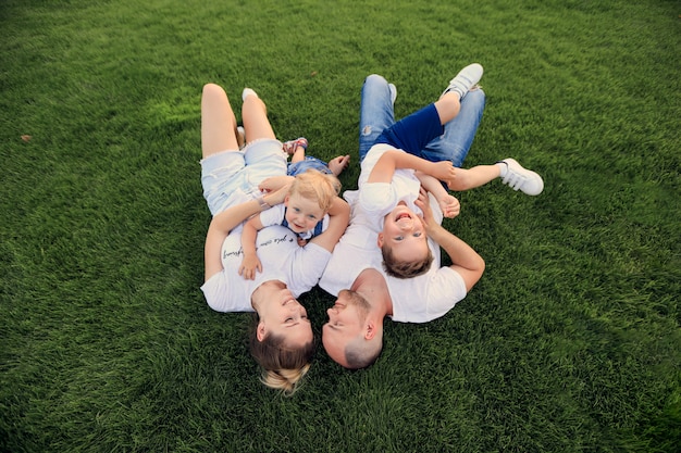 Foto moeder en vader spelen in het park met hun kinderen