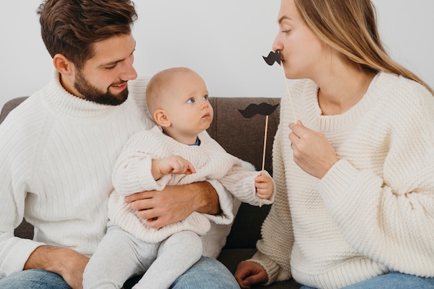 Foto moeder en vader spelen thuis met baby