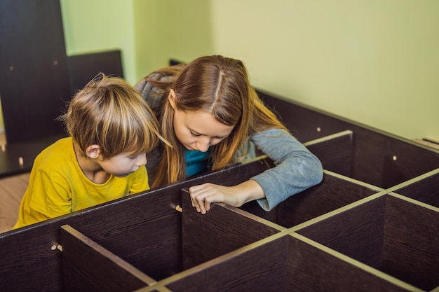 Moeder en zoon assembleren meubels Jongen die zijn moeder thuis helpt Happy Family concept