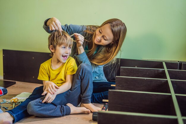 Moeder en zoon die meubels monteren Jongen die zijn moeder thuis helpt Happy Family concept