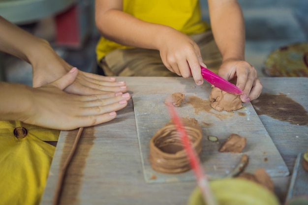 Foto moeder en zoon doen keramische pot in pottenbakkerij wat te doen met kinderen kindvriendelijke plek