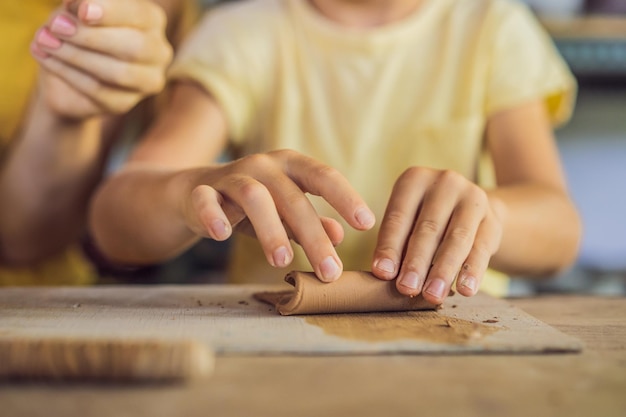 Moeder en zoon doen keramische pot in pottenbakkerij