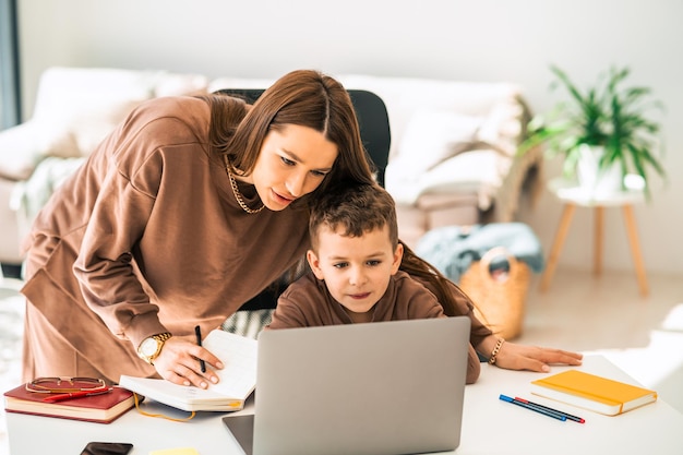 Moeder en zoon doen school huiswerk op laptop