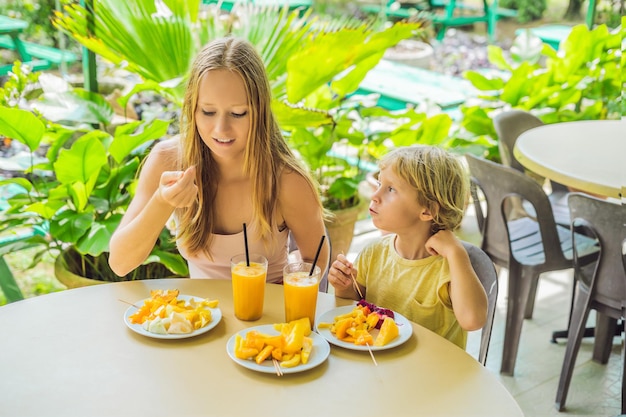 Moeder en zoon eten fruit en sap in een café