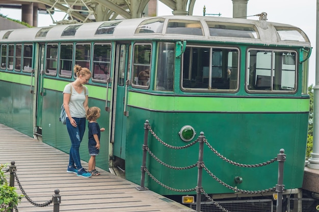 Moeder en zoon gaan op een oude tram. Reizen met kinderen in Hong Kong concept