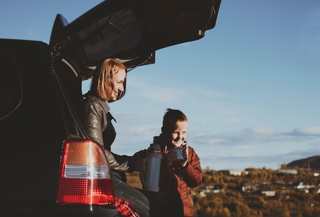 Moeder en zoon in de auto tegen de lucht.