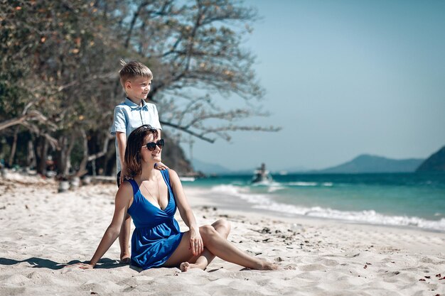 Moeder en zoon kijken samen naar de zee. Moeder houdt de hand van haar kind vast. Zomer zee vakantie concept. Phuket. Thailand. Mooie zee