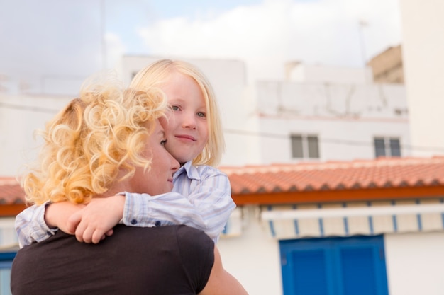 Moeder en zoon kinderen knuffelen en liefhebben samen met geluk