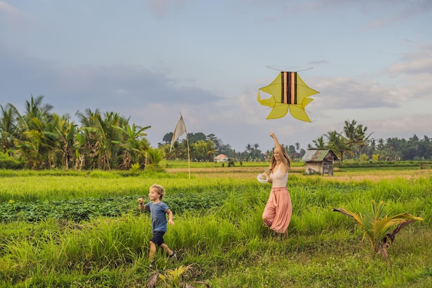 Moeder en zoon lanceren een vlieger in een rijstveld in Ubud, Bali, Indonesië