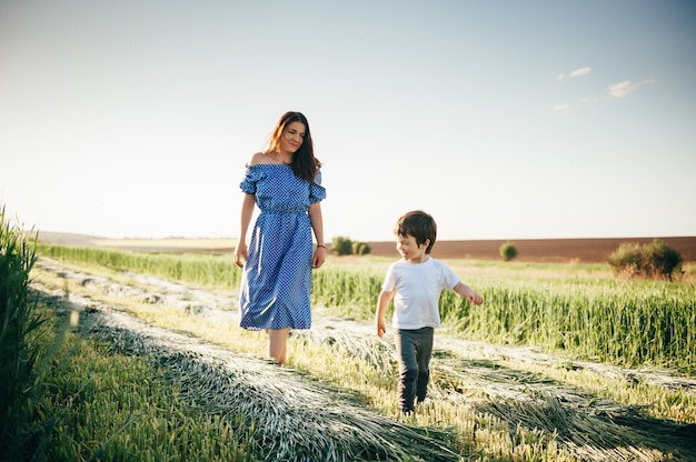 Moeder en zoon lopen op tarweveld