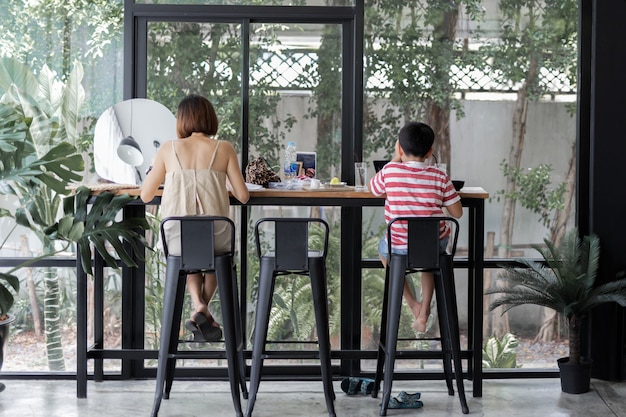 Moeder en zoon lunchen samen in café.