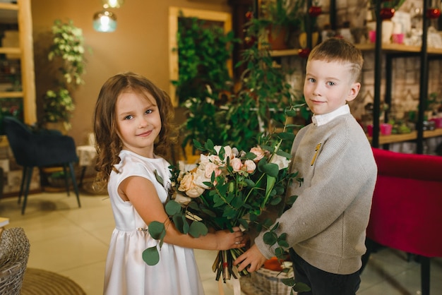 Moeder en zoon met bloemen in caffe. Zoon geeft bloemen aan moeder. schattige familie. Internationale Vrouwendag, 8 maart vieren