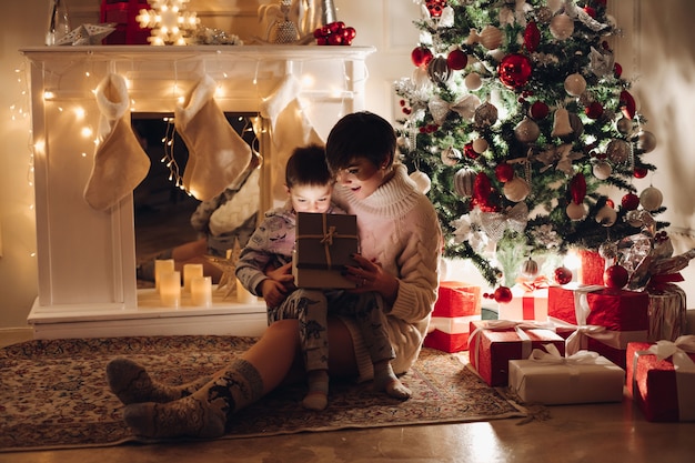 Moeder en zoon openen een kerstcadeau in een doos