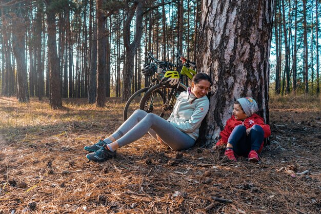 Foto moeder en zoon rusten in het bos tijdens een fietstocht foto