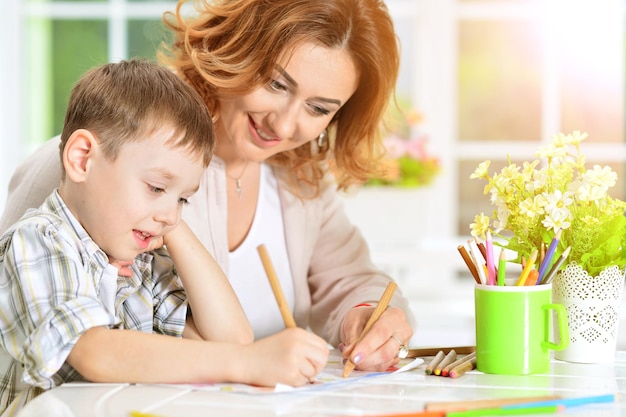 Moeder en zoon schilderen samen met potloden