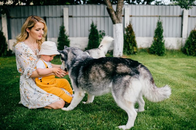 Moeder en zoon spelen met twee honden in de tuin