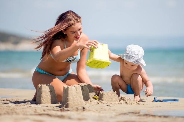 Moeder en zoon spelen op het strand