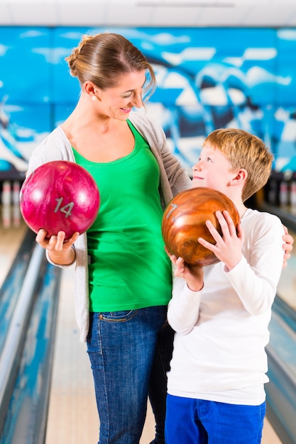 Foto moeder en zoon spelen samen op bowlingcentrum