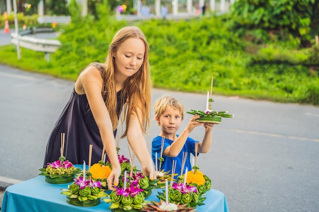 Moeder en zoon toeristen houden de loy krathong in haar handen en staan op het punt hem in het water te lanceren