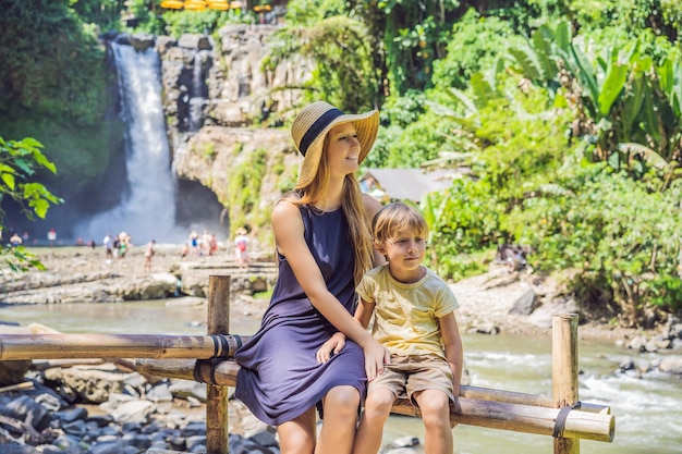 Moeder en zoon toeristen op de achtergrond van een waterval Reizen met kinderen concept Wat te doen met kinderen Kindvriendelijke plek