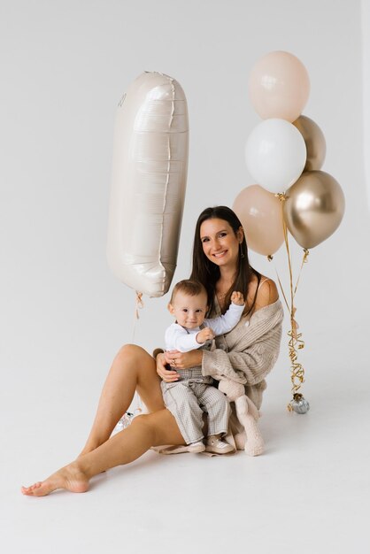 Moeder en zoon vieren hun eerste verjaardag met ballonnen.