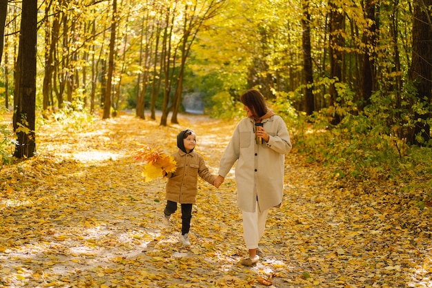 Moeder en zoon wandelen in het herfstbos herfst buitenactiviteit voor gezin met kinderen