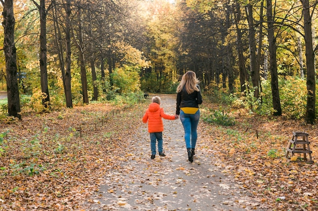 Moeder en zoon wandelen in het herfstpark en genieten van het prachtige herfstseizoen single
