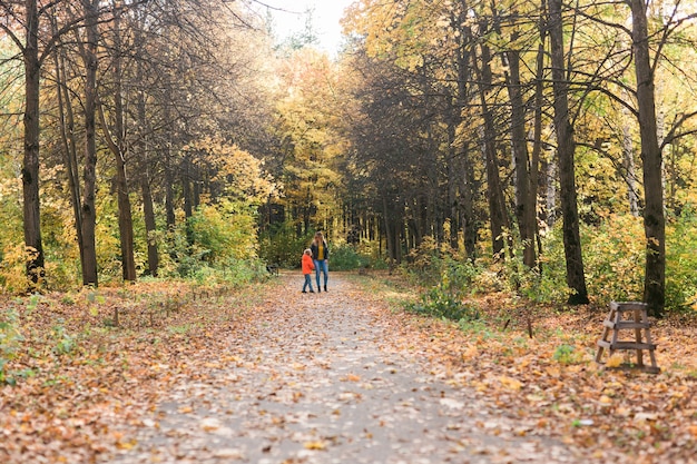 Moeder en zoon wandelen in het herfstpark en genieten van het prachtige herfstseizoen single