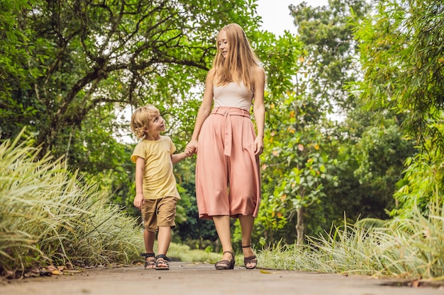 Moeder en zoon wandelen in het tropische park